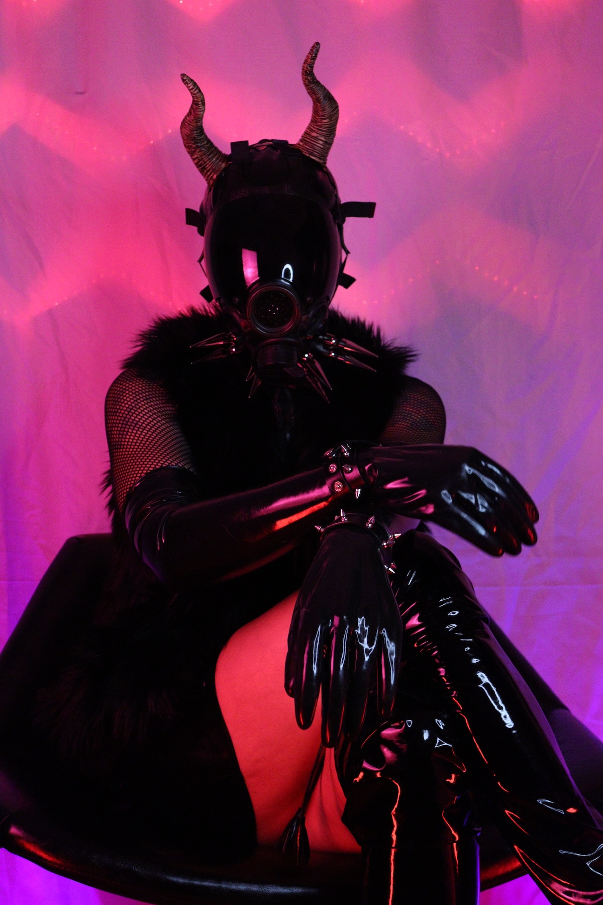 Picture of me, wearing a black latex top over a fishnet shirt, long black latex gloves and black latex skirt with a read streak. Also, I'm wearing a thigh-high black vinyl boots, a gas mask and a pair of horns.